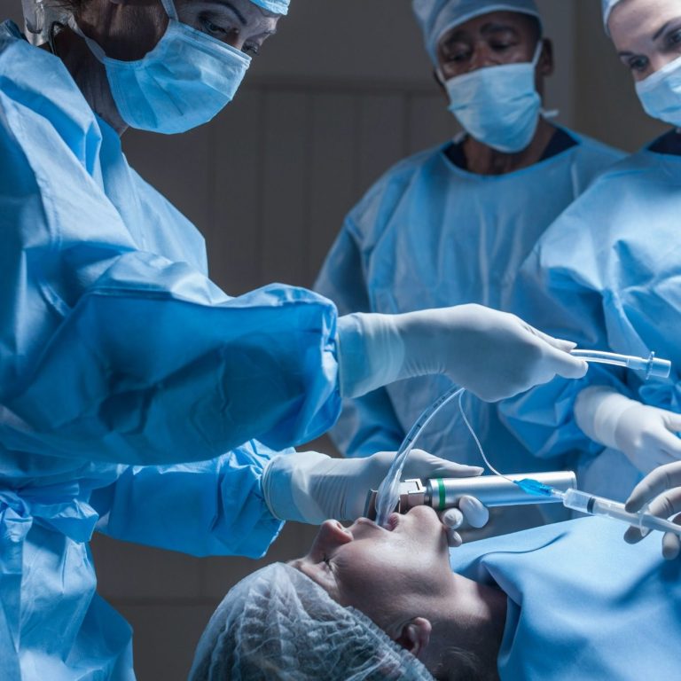 Medical team performing surgery with a patient under anesthesia.
