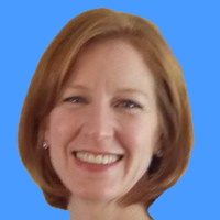 Smiling woman with shoulder-length red hair against a blue background.
