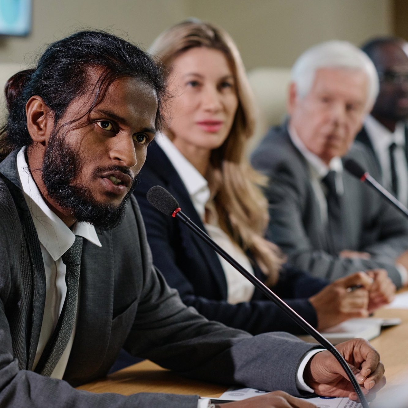 A diverse group of professionals at a conference table, engaged in discussion.