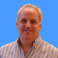 Smiling man in a striped shirt with a blue background.
